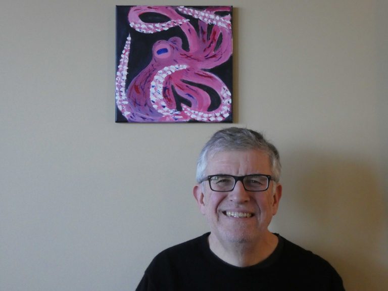 Picture of Christian in front of Octopus logo